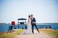 Bryllupsfotograf. Brudepar ved havet